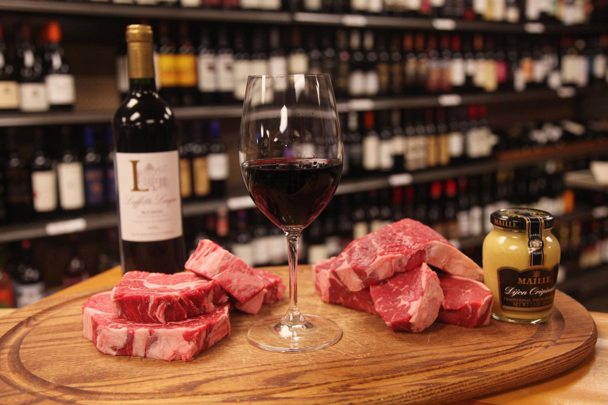 A high quality bottle of wine and a ribeye steak on a table